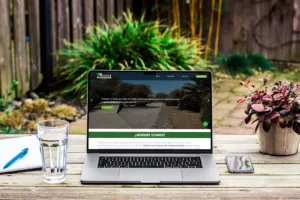 Free MacBook Pro On Wood Desk In Garden Mockup copia